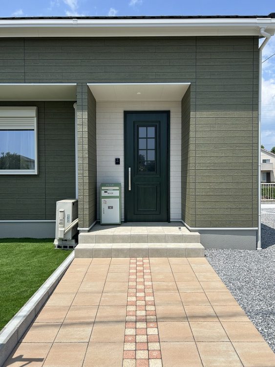 新築外構　オレンジ色のアプローチと人工芝の緑が映える施工例